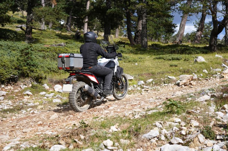 A man riding an off-road motorcycle on a mountain road