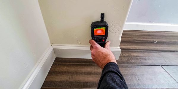 Using a thermal camera to check a corner of a room.