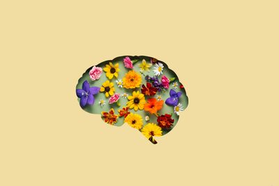 Brain-shaped cutout filled with colorful flowers on a pastel background.