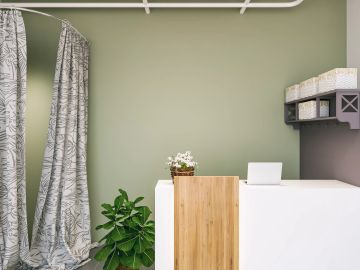 Minimalist reception area with plants and storage baskets.