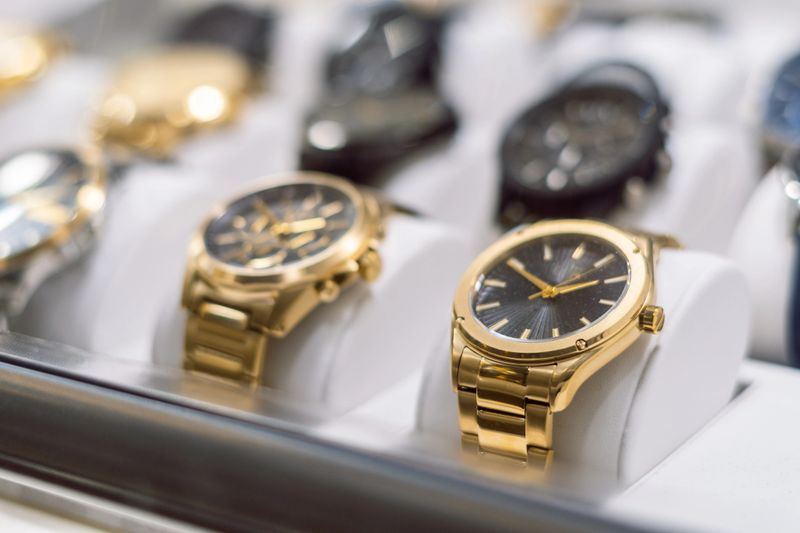 High-end gold-colored watches, exposed behind the window of a watch shop