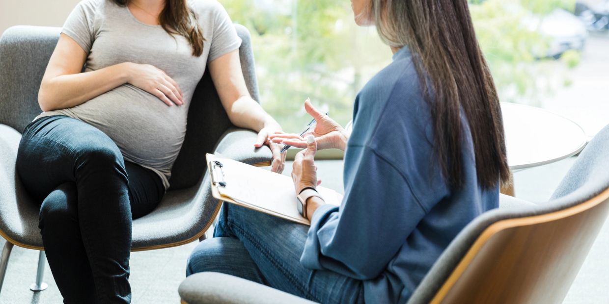 A pregnant woman consulting with a healthcare professional.
