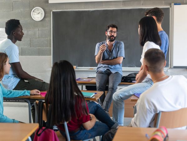 An educator having a discussion with his students