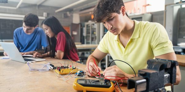 Students working on electronics projects in a classroom.