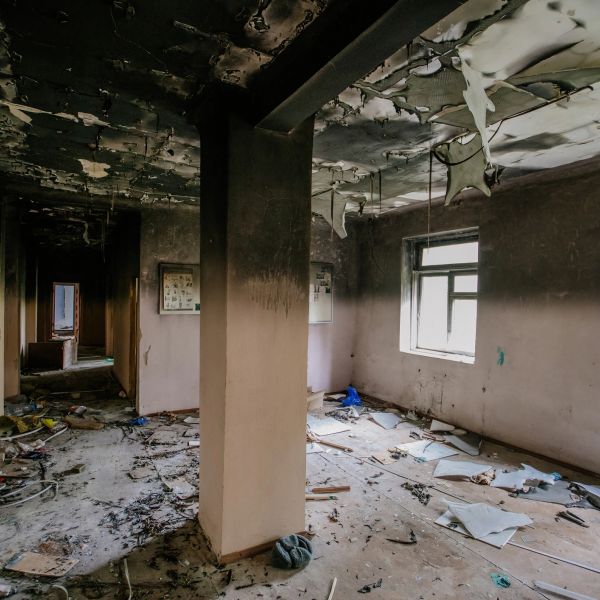 Abandoned room with peeling ceiling and scattered debris.