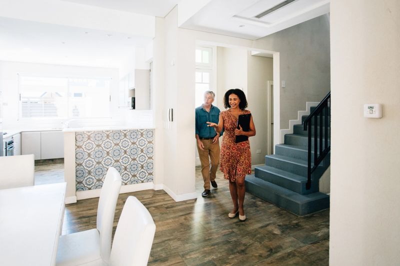 Real estate agent showing house to senior client