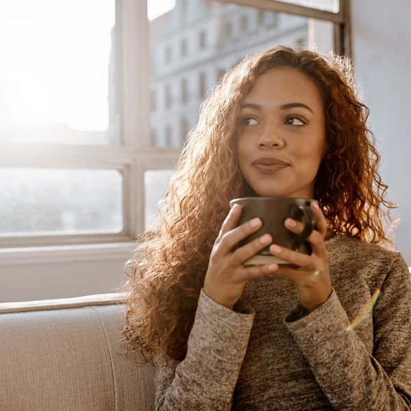 Woman enjoying a warm drink by the window.