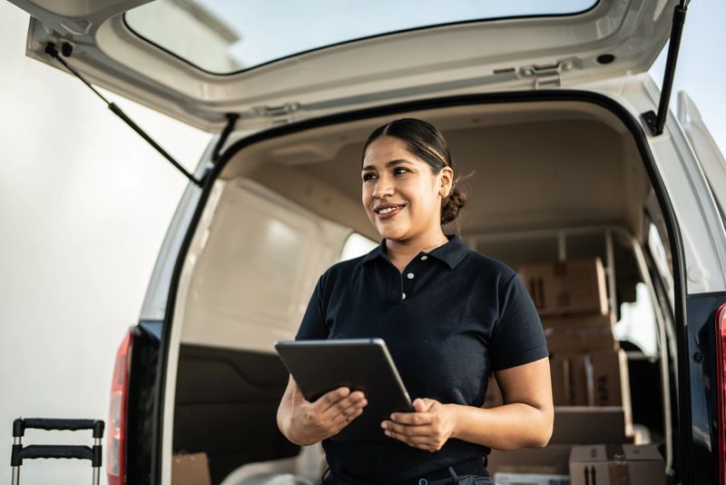 Delivery person using digital tablet outdoors