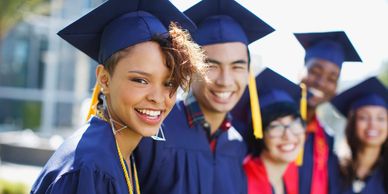 Group of smiling graduates in caps and gowns.