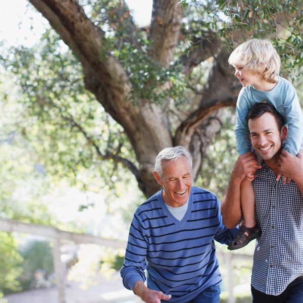 Three generations of men enjoying a sunny walk outdoors together.
