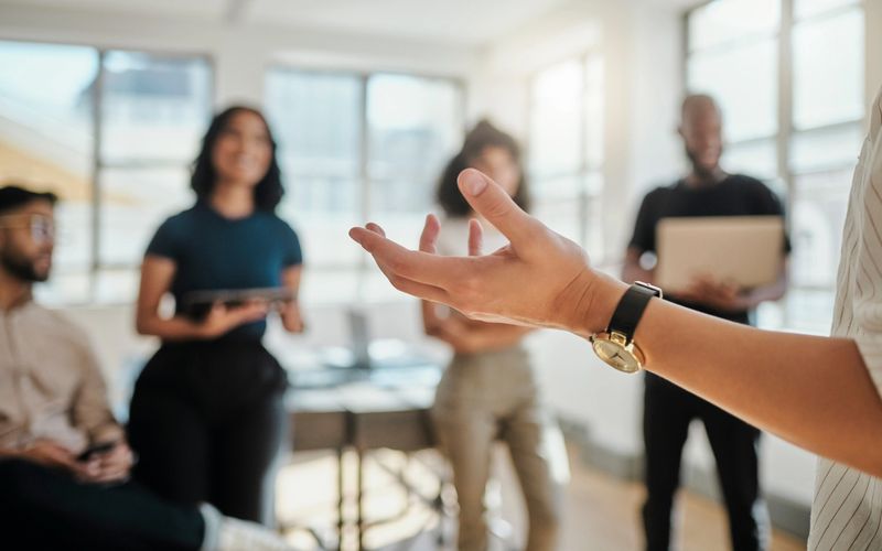 Motivation, coaching and presentation with team building meeting in an office by business people and a mentor. Leadership, management and training with team learning growth and marketing strategy