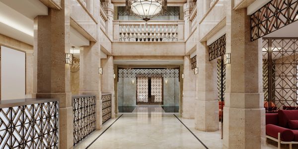 Elegant marble hallway with classical columns and ornate iron railings.