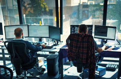 Two people working on computers in an office.
