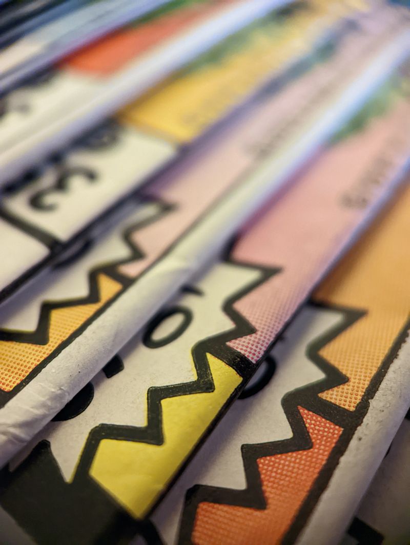 Closeup view of an old comic book collection stacked in a pile creates a colorful background paper texture with abstract shapes