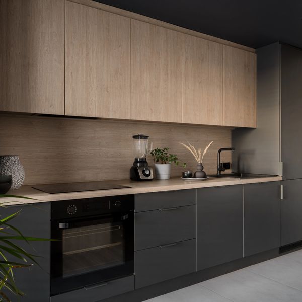 Modern kitchen with black and wood cabinetry and minimalist decor.