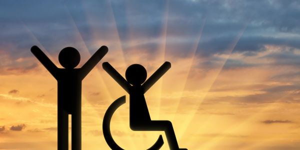 Icons of a standing person and a person in a wheelchair celebrating at sunset.