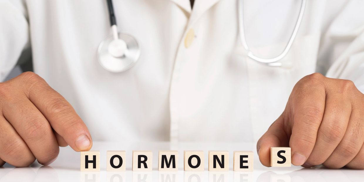 Doctor arranging blocks that spell 'HORMONES'.