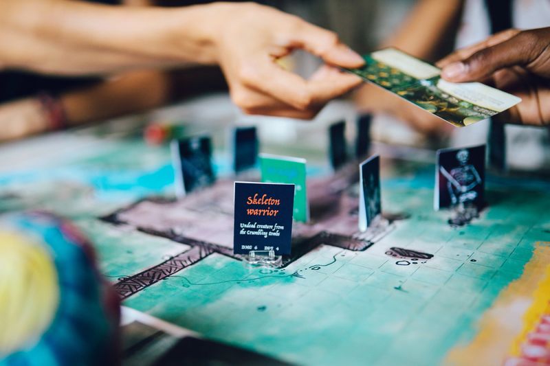 Female friends playing fantasy role playing games on the table. Close up on the one of the characters on the playfield.
