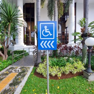 Blue sign indicating a wheelchair-accessible ramp to the left.