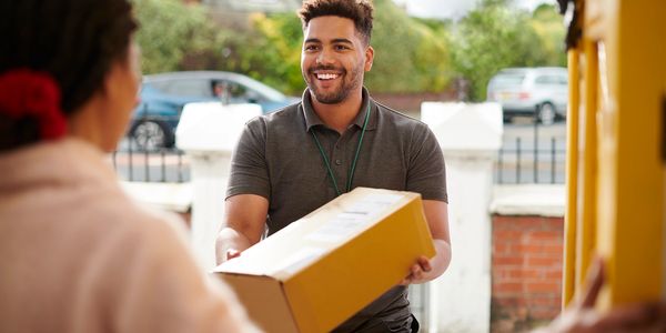 Delivery man handing a package to a woman.