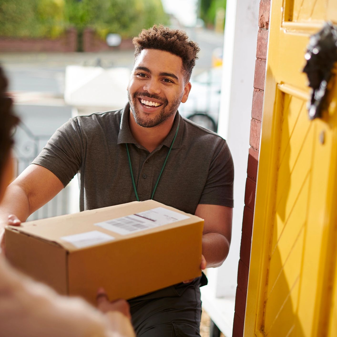 Smiling delivery man handing over a package at the door.
