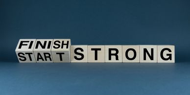 Wooden blocks show "START FINISH STRONG" message on a blue background.