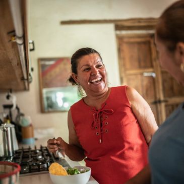 Mujer feliz cocinando y conversando en la cocina.