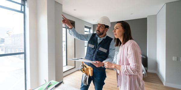 Man and woman reviewing interior progress of a home under renovation