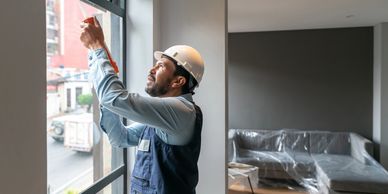 Window Cleaner inspecting and cleaning a post construction window