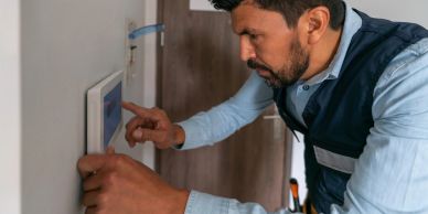 Man operating a wall-mounted control panel.