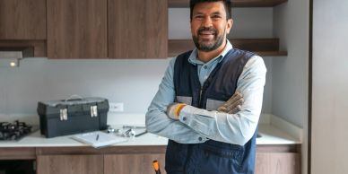 Confident handyman stands in a modern kitchen.
