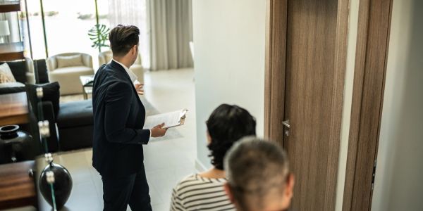 People waiting outside a room while a man checks inside.