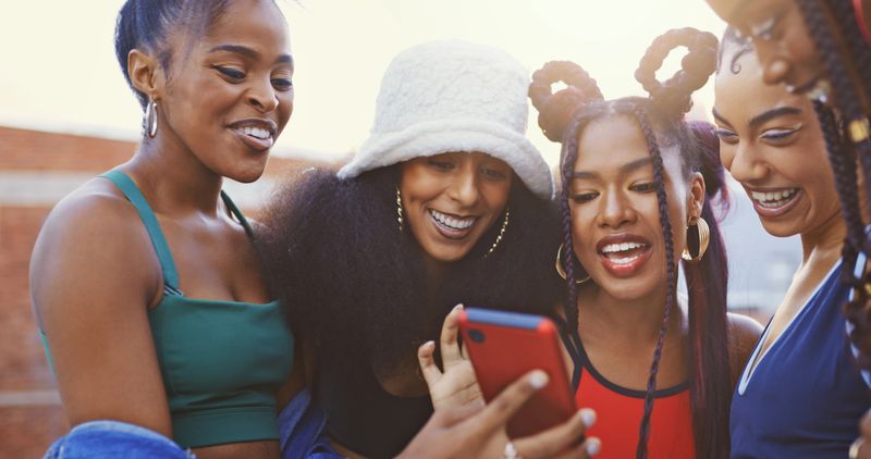 Friends, phone and happy for meme, social media or video on web together. Black woman, group and smartphone laugh to show happiness, funny and comic reaction to app, blog or comedy on internet