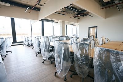 New office space with chairs covered in protective plastic.