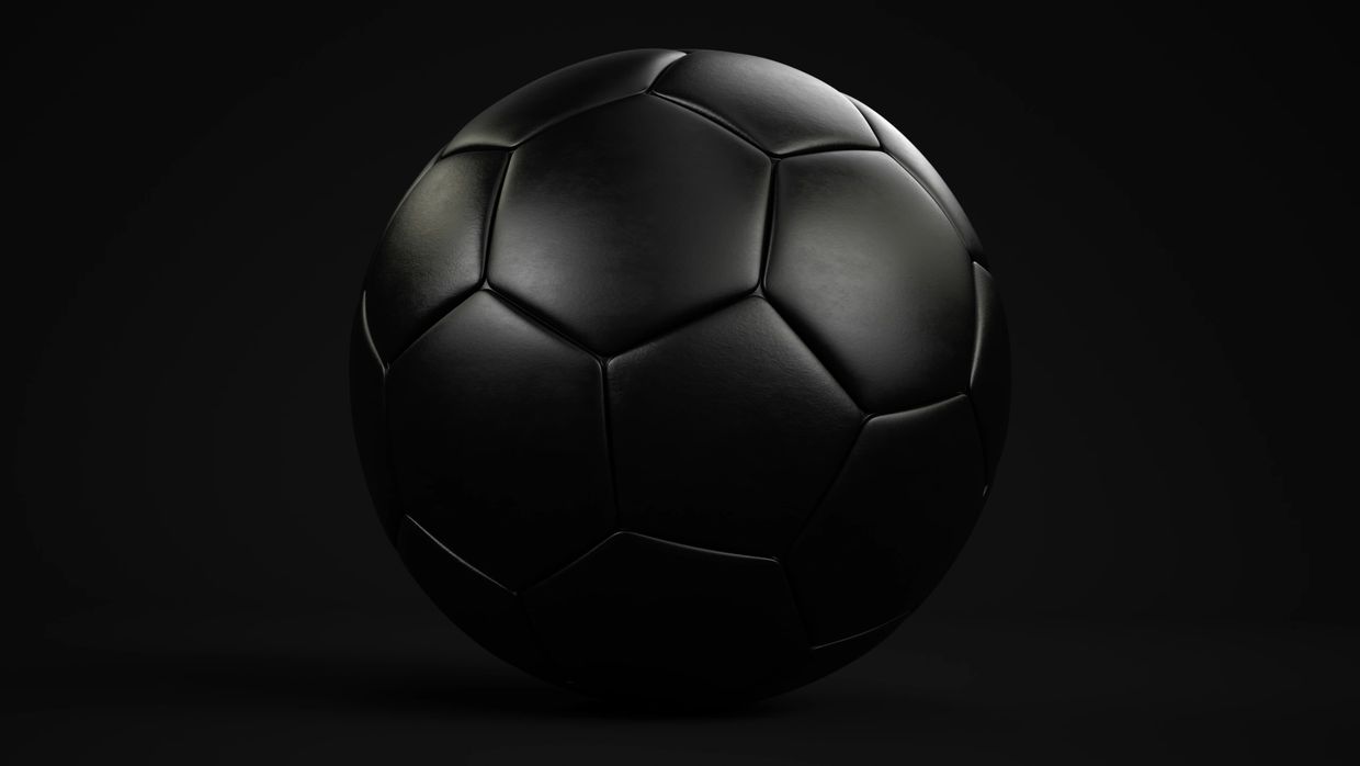 Sleek black soccer ball with subtle highlights on a dark background.