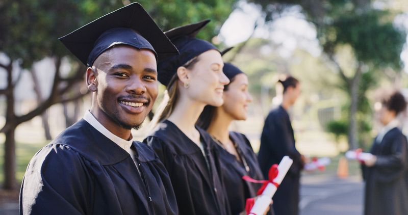 Graduation, success and black man or students at university for study goal, certificate achievement or diploma award scholarship. College or academy class graduate group in an outdoor campus portrait