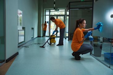 Two person wearing the same color tshirt and cleaning the floor and cabin door.