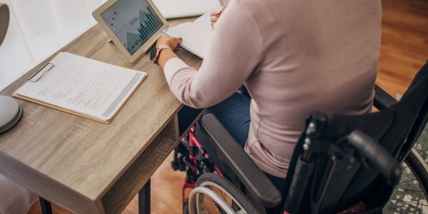 Person in wheelchair analyzing data on tablet.