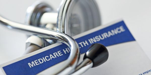 A stethoscope resting on a Medicare health insurance card.