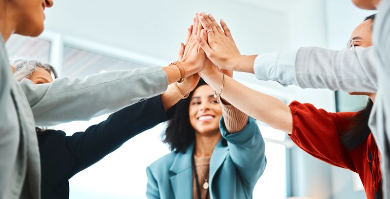 Hands, high five and team building in office with workers connecting in support of success and fun. Teamwork, collaboration and hand in solidarity of community goal, vision and mission for success