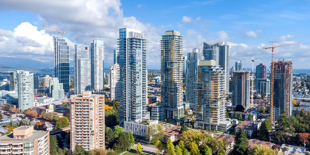 Modern cityscape with high-rise buildings under a bright blue sky.