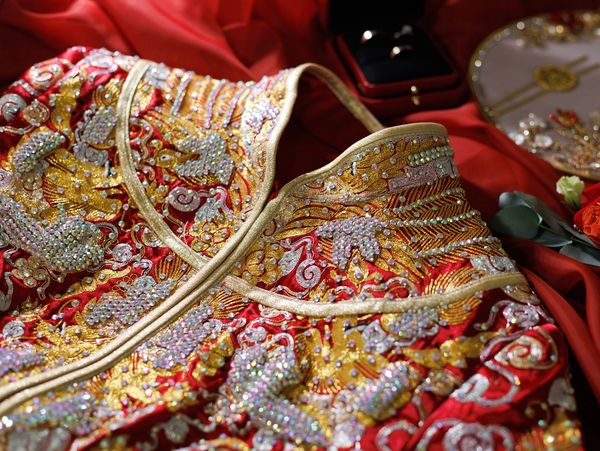 Intricately embroidered traditional garment with gold and red accents.