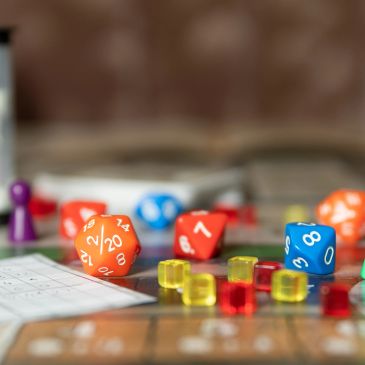 Close-up of dice, tokens, and game pieces on a board game setup.