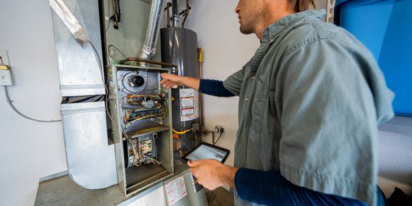 A man inspecting a gas furnace.