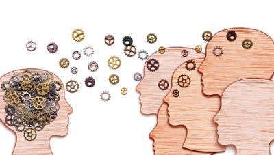 Wooden heads with gears symbolize knowledge transfer and idea sharing.