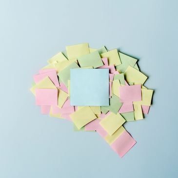 Colorful sticky notes arranged in a brain shape on a blue background.