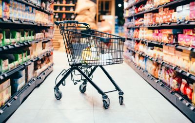 A shopping cart in the aisle of a grocery store.