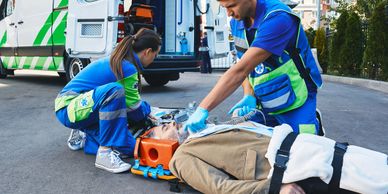 Paramedics providing emergency care to an injured man on a stretcher.