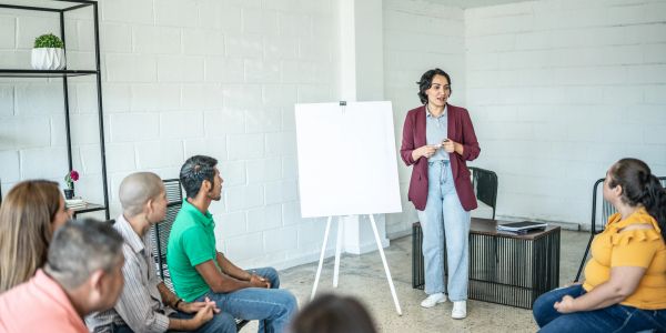 Woman presenting to a small group in a casual setting.