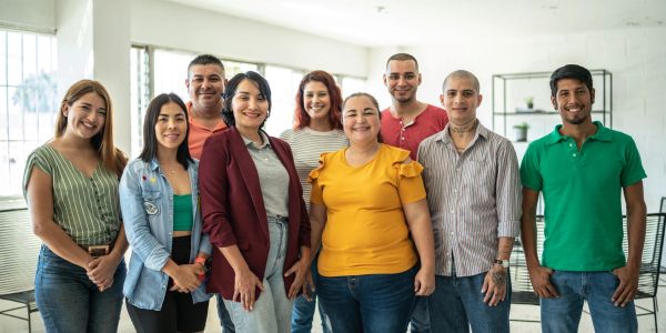 Group of smiling young adults posing indoors.